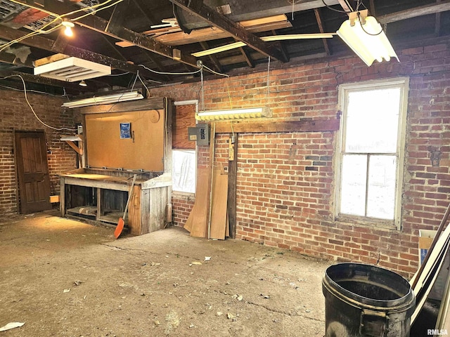 misc room with a healthy amount of sunlight and brick wall