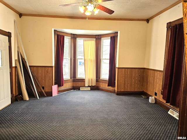 carpeted spare room with ceiling fan and ornamental molding