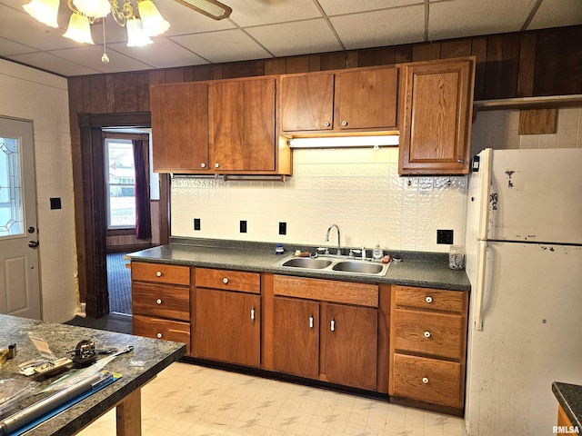 kitchen with a paneled ceiling, white fridge, ceiling fan, and sink