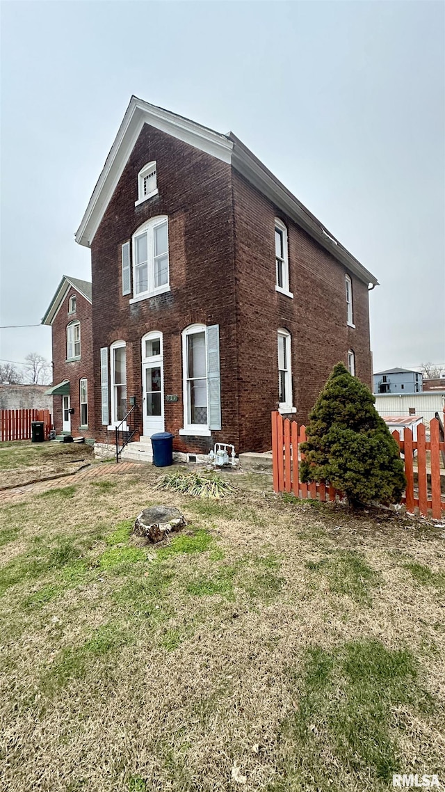 exterior space featuring cooling unit and a front lawn