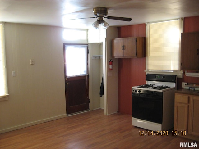 kitchen featuring white gas range oven, hardwood / wood-style flooring, and ceiling fan