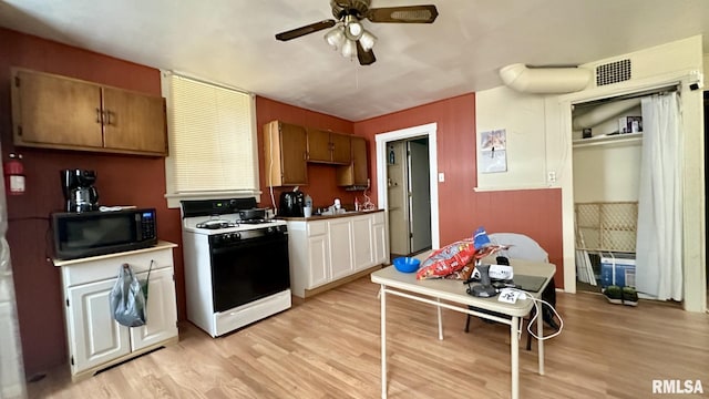 kitchen featuring ceiling fan, light wood-type flooring, and white gas range