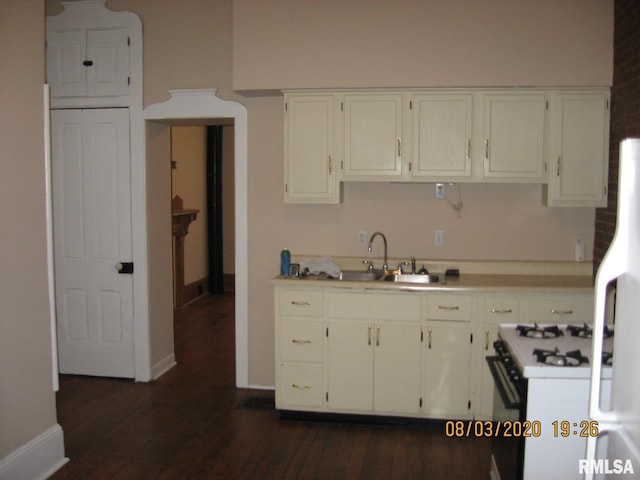 kitchen with dark hardwood / wood-style flooring, white appliances, white cabinetry, and sink