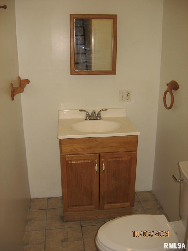 bathroom with tile patterned flooring, vanity, and toilet