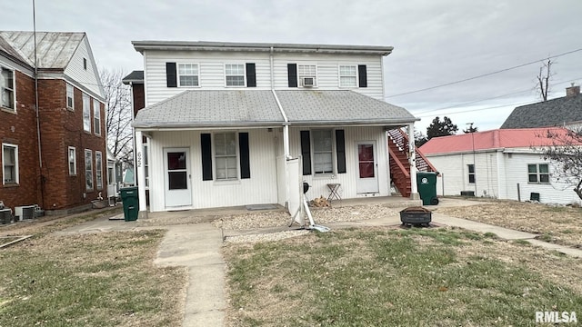 view of front of property featuring central AC unit, covered porch, and a front yard