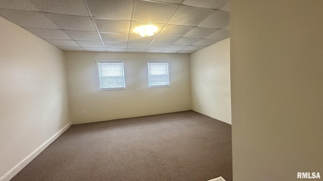 carpeted empty room featuring a paneled ceiling