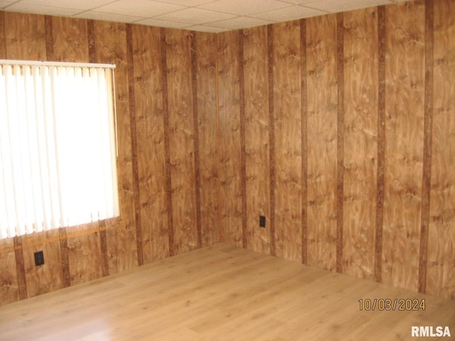 unfurnished room with hardwood / wood-style floors and wood walls