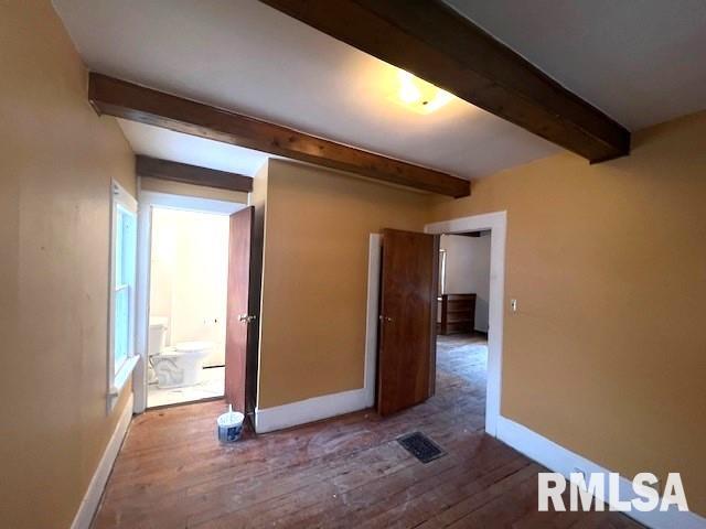 interior space featuring hardwood / wood-style floors and beamed ceiling