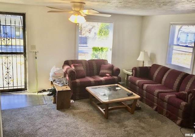 carpeted living room with ceiling fan and a textured ceiling