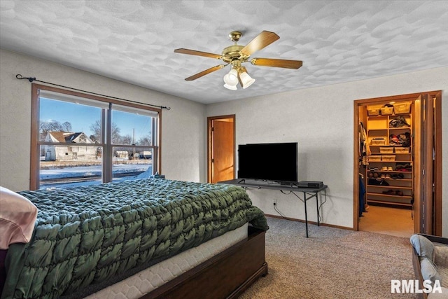 carpeted bedroom featuring ceiling fan and a textured ceiling