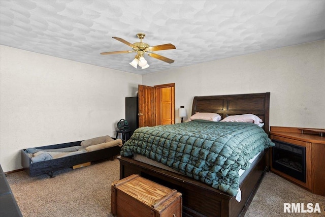 bedroom with ceiling fan, carpet floors, and a textured ceiling