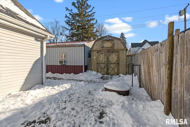 snowy yard featuring a storage unit and cooling unit