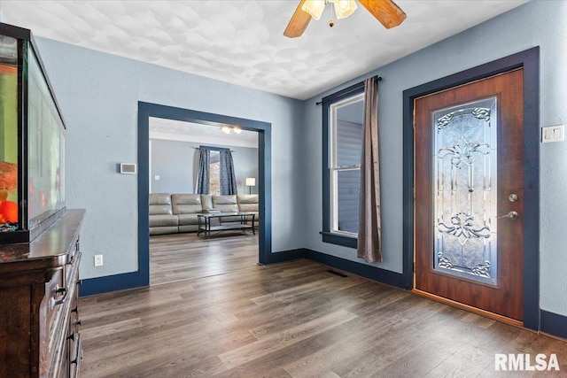 entryway featuring ceiling fan and dark wood-type flooring