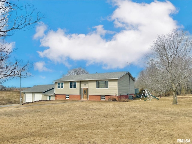 raised ranch with a garage, a front lawn, and a playground