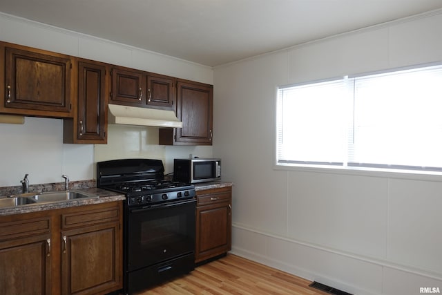 kitchen with crown molding, black gas stove, light wood-type flooring, and sink