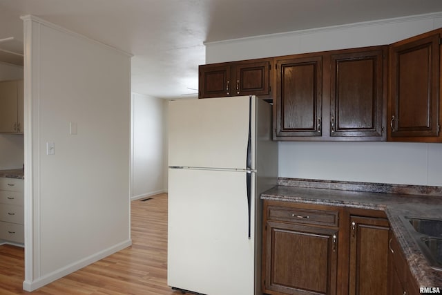 kitchen with white fridge and light hardwood / wood-style flooring