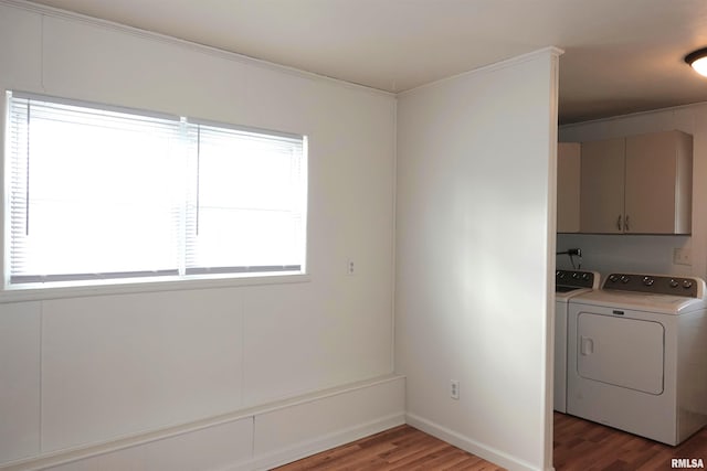 laundry area featuring cabinets, washer and dryer, and dark hardwood / wood-style flooring