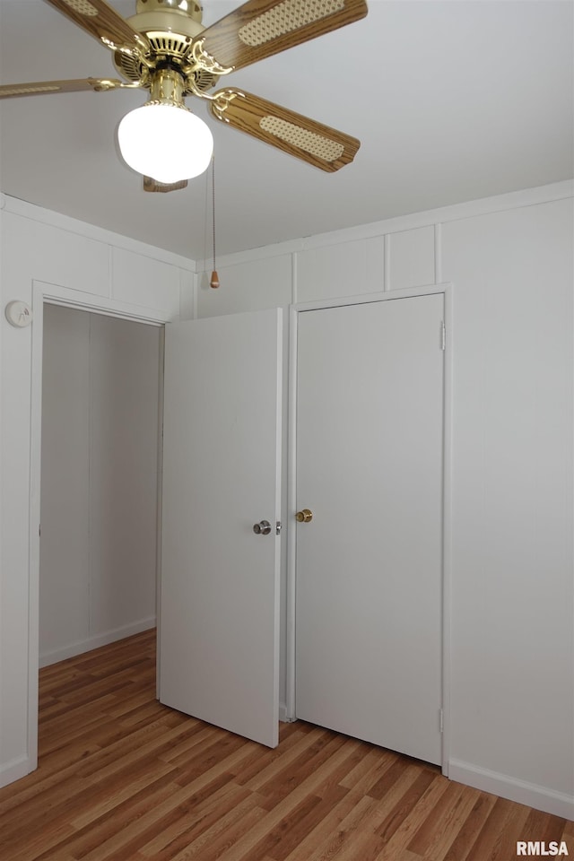 unfurnished bedroom featuring a closet, hardwood / wood-style flooring, and ceiling fan