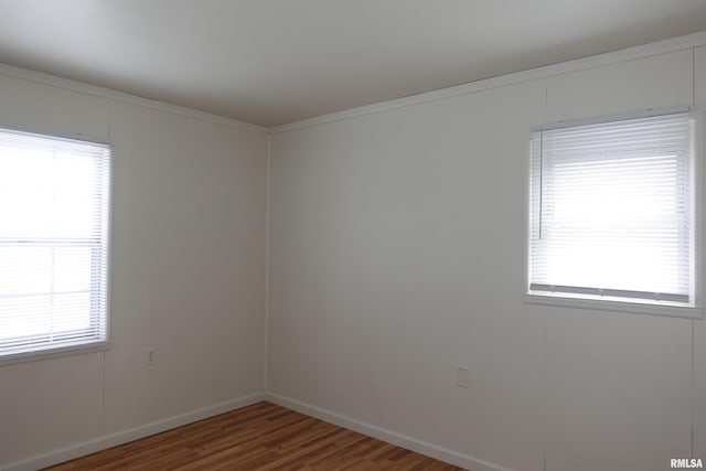 spare room with hardwood / wood-style floors and ornamental molding