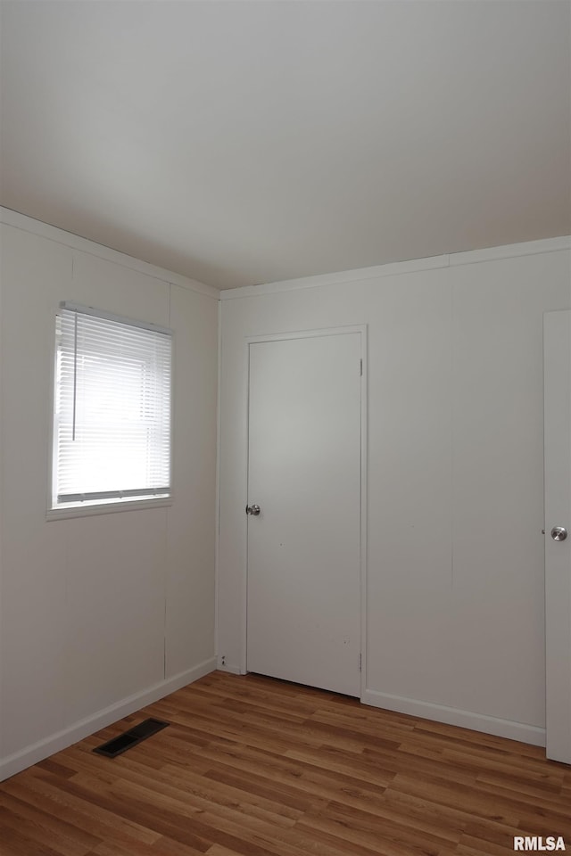 unfurnished room with hardwood / wood-style flooring