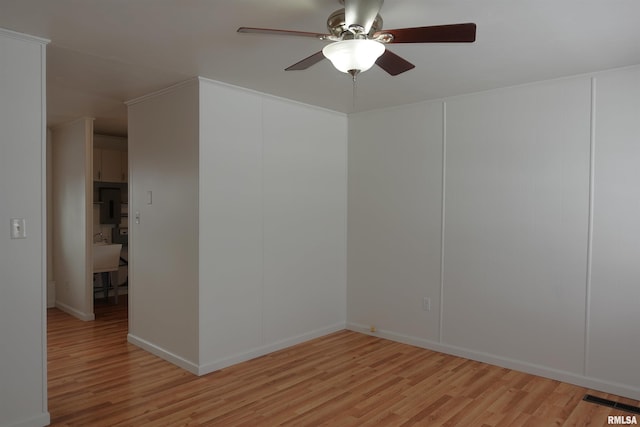 empty room featuring ceiling fan and light hardwood / wood-style flooring