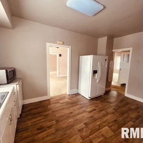 kitchen with sink, dark hardwood / wood-style flooring, white cabinets, and white fridge with ice dispenser