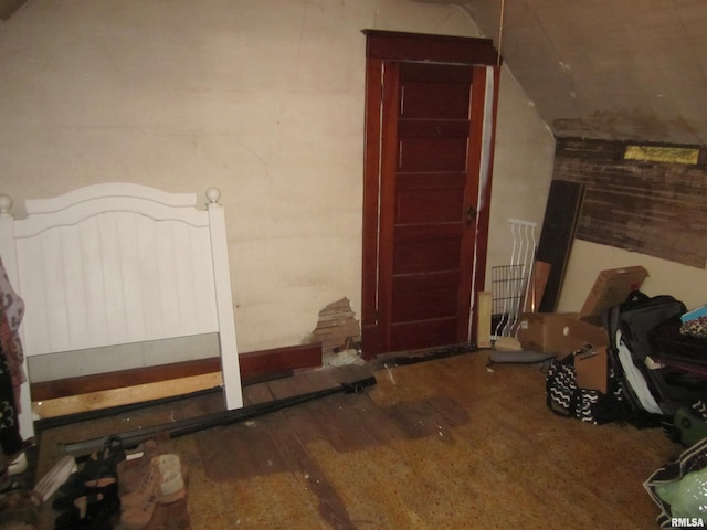 bedroom with hardwood / wood-style flooring and lofted ceiling