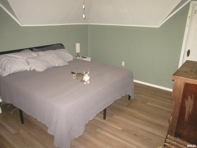 bedroom featuring vaulted ceiling and light hardwood / wood-style flooring