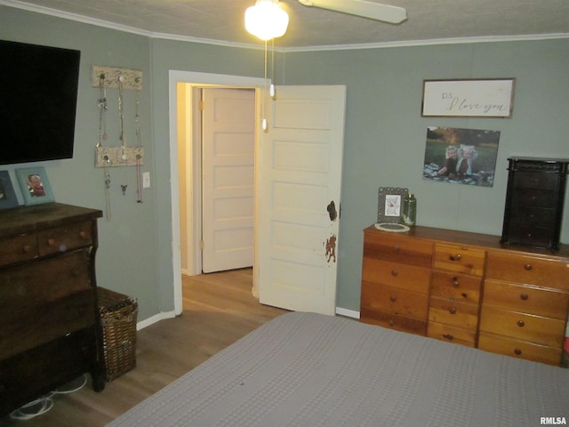 bedroom with ceiling fan, light hardwood / wood-style floors, and ornamental molding