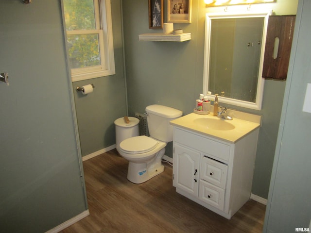 bathroom with hardwood / wood-style floors, vanity, and toilet