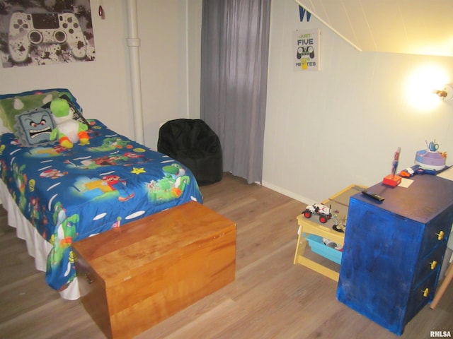 bedroom featuring hardwood / wood-style floors and lofted ceiling