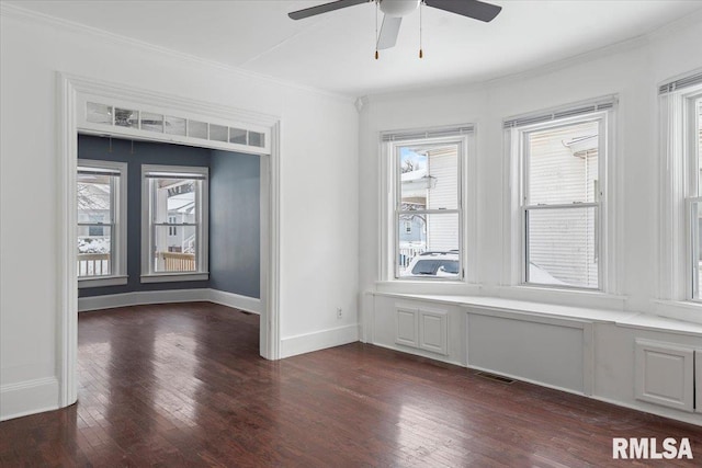 empty room featuring crown molding, dark hardwood / wood-style floors, and ceiling fan