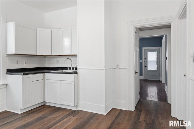 kitchen featuring white cabinetry, sink, backsplash, and dark hardwood / wood-style floors