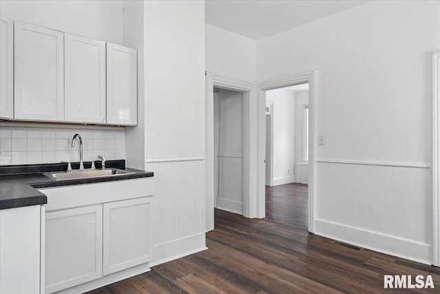 kitchen featuring tasteful backsplash, sink, white cabinets, and dark hardwood / wood-style floors