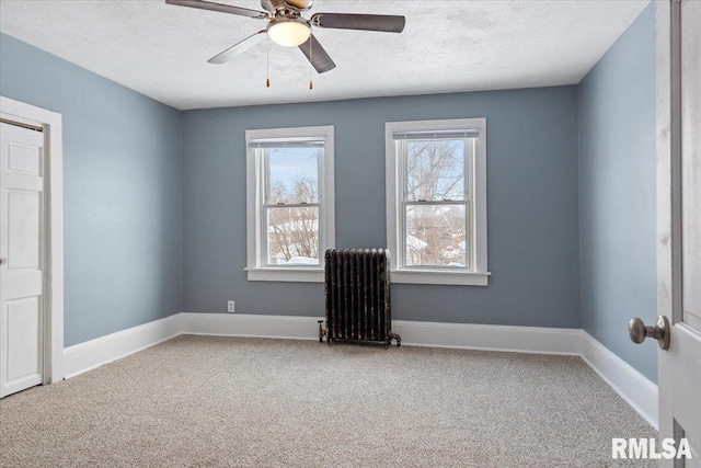 unfurnished room with radiator, carpet floors, and plenty of natural light