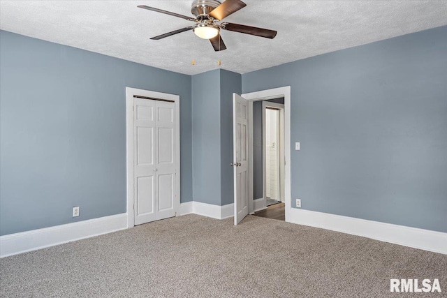 unfurnished bedroom featuring ceiling fan, a closet, a textured ceiling, and carpet flooring