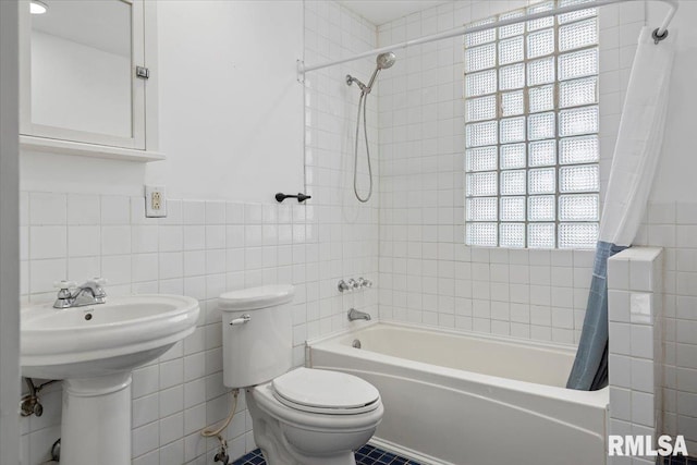 bathroom featuring shower / bath combination with curtain, toilet, and tile walls