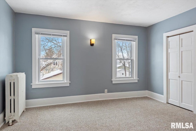 unfurnished bedroom with radiator, carpet floors, a closet, and a textured ceiling