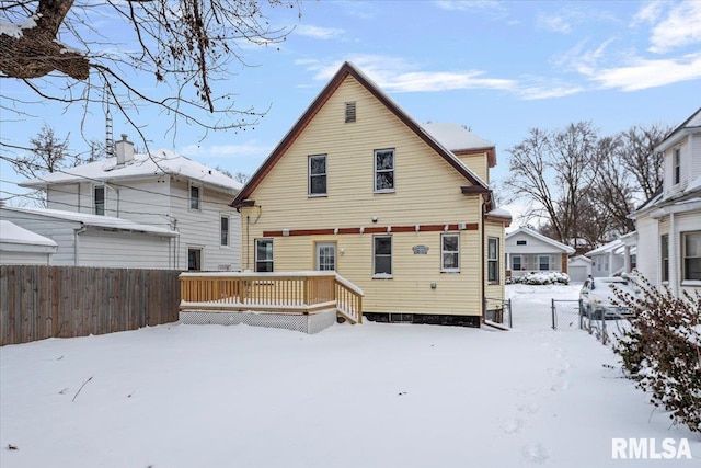 snow covered house featuring a deck