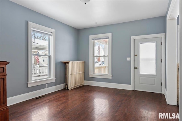 entrance foyer with radiator heating unit and dark wood-type flooring