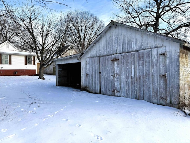 snow covered structure featuring an outbuilding