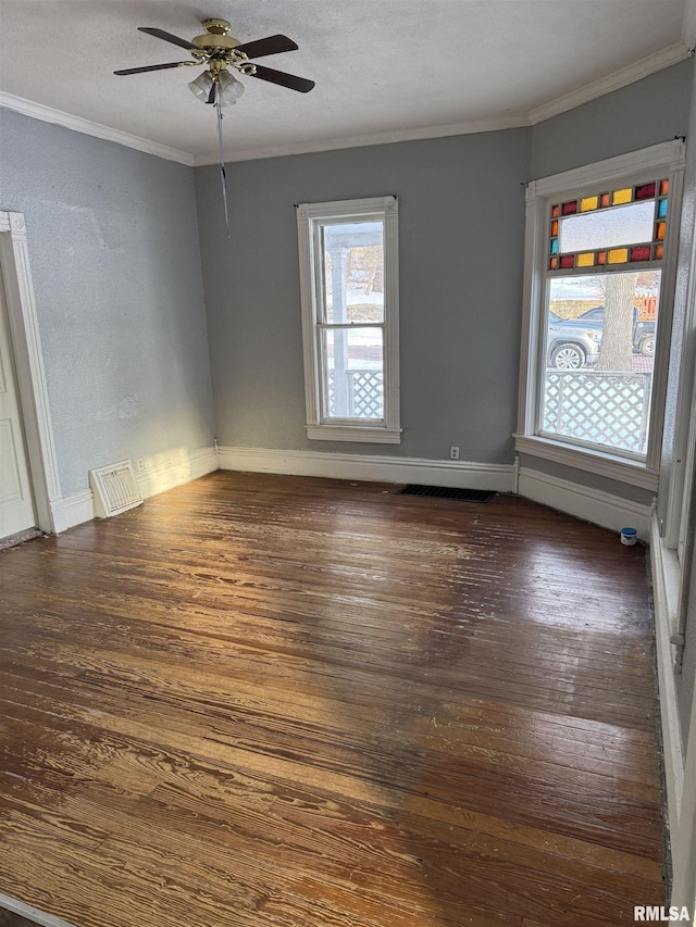 spare room with dark wood finished floors, a ceiling fan, baseboards, and ornamental molding