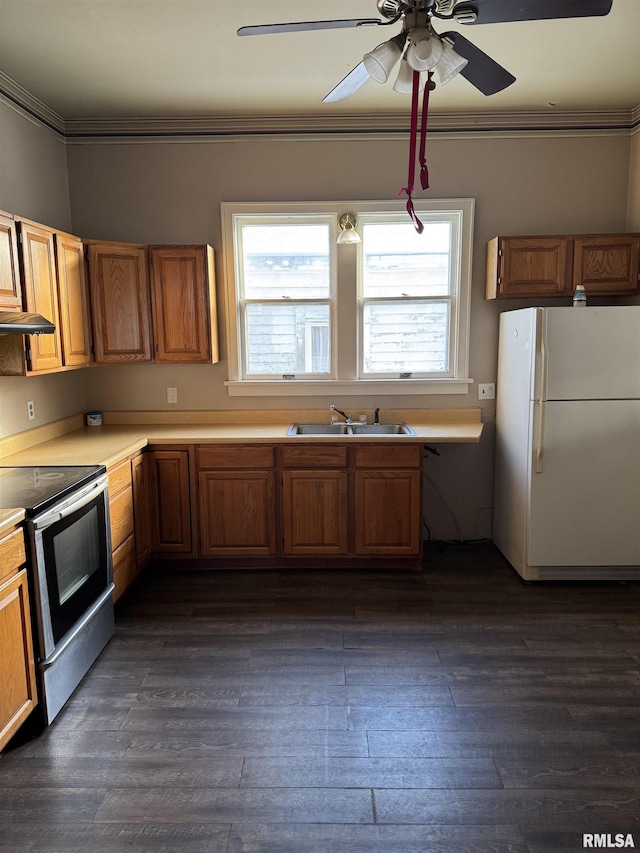 kitchen with a sink, stainless steel range with electric cooktop, freestanding refrigerator, crown molding, and light countertops