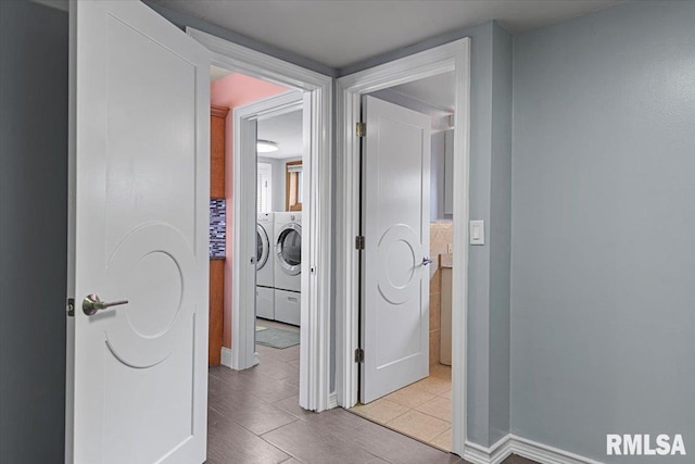 corridor with washing machine and dryer and light tile patterned flooring