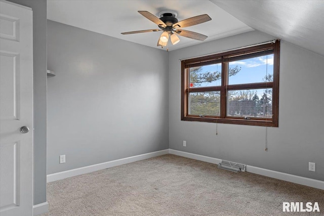 spare room featuring ceiling fan, light colored carpet, and lofted ceiling