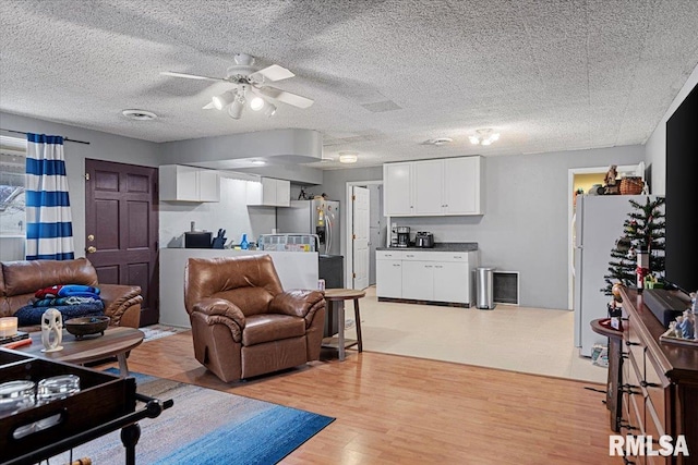 living room featuring ceiling fan and light hardwood / wood-style floors