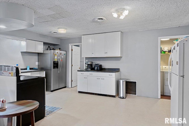 kitchen with white cabinetry, washing machine and dryer, stainless steel fridge, and white fridge