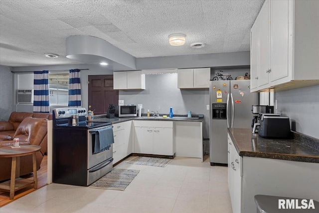 kitchen featuring white cabinets, sink, an AC wall unit, and stainless steel appliances