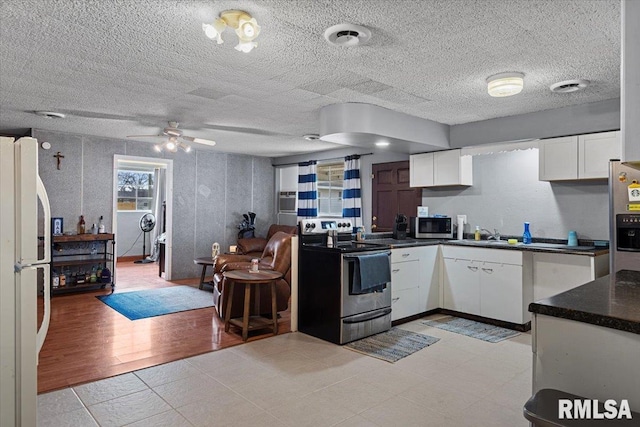 kitchen featuring white cabinets, sink, ceiling fan, light wood-type flooring, and appliances with stainless steel finishes