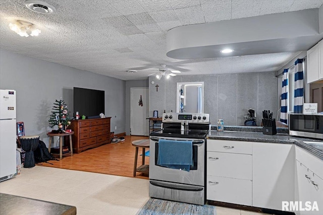 kitchen featuring white cabinetry, light hardwood / wood-style flooring, ceiling fan, and appliances with stainless steel finishes